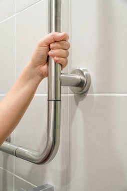 Küpeşte tuvalet üzerinde tutan kadın.