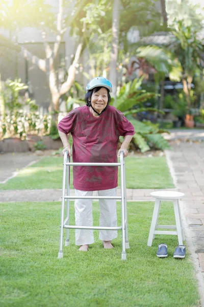 Femme âgée marchant pieds nus thérapie sur l'herbe dans la cour arrière . — Photo