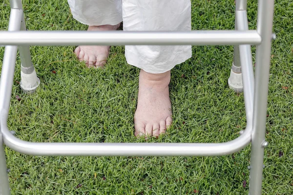 Bejaarde vrouw lopen blootsvoets therapie op gras in achtertuin. — Stockfoto