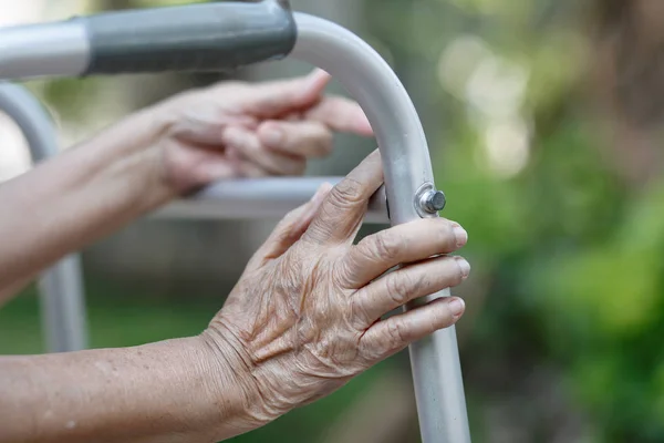 Пожилая женщина использует ходунки на заднем дворе — стоковое фото
