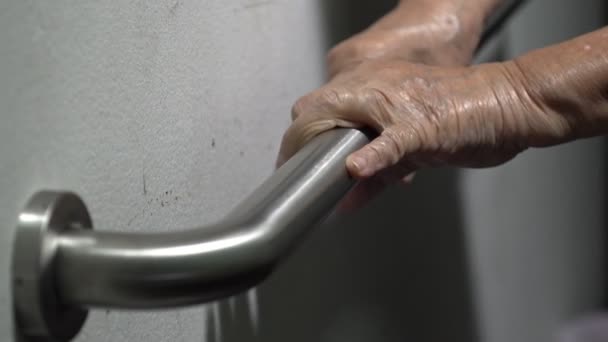 歩行支援用の手すりを持つ高齢者女性の手 — ストック動画