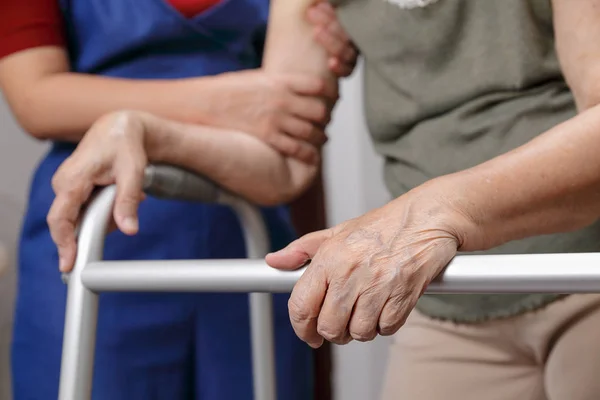 Ältere asiatische Frau mit einem Rollator zu Hause mit Tochter nehmen ca — Stockfoto