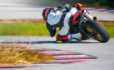 Yarış pistinde hızlı bir viraja yaslanan motosiklet