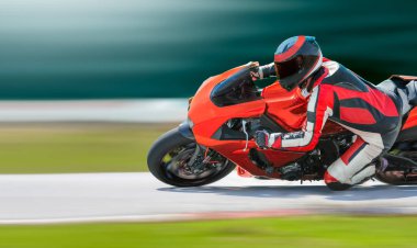 Yarış pistinde hızlı bir viraja yaslanan motosiklet