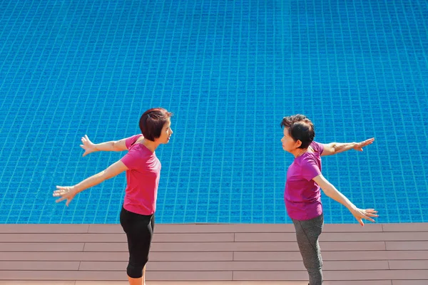 Starší žena dělá cvičení s dcerou v bazénu terasa — Stock fotografie