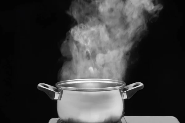 Vapor sobre la olla de cocina en la cocina sobre fondo oscuro —  Fotos de Stock