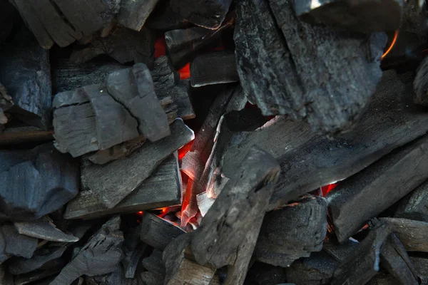 Nærbillede af trækul er begyndt at brænde i køkkengrillen. Varmt kul og flamme med røg. - Stock-foto