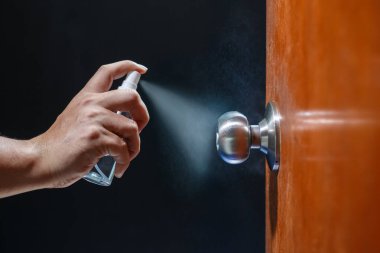 Covid-19 (Coronavirus) önleme için alkol spreyi ile kapı tokmağı temizleme.