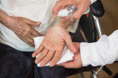Yaşlı kadın, Coronavirus covid-19 'dan korunmak için bakıcıdan bir maske alır.