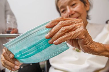 Coronavirus covid-19 'dan korumak için maske takan yaşlı bir kadın.