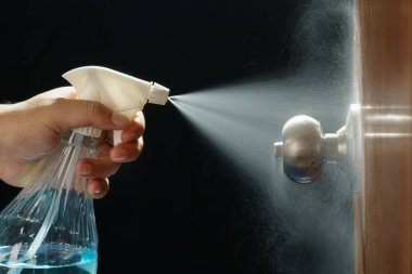 Covid-19 (Coronavirus) önleme için alkol spreyi ile kapı tokmağı temizleme.