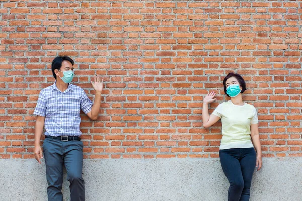 Asian middle aged people wearing mask and keep social distancing to avoid the spread of COVID-19