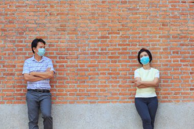 Maske takan Asyalı orta yaşlı insanlar COVID-19 'un yayılmasını önlemek için sosyal mesafeyi koruyorlar.