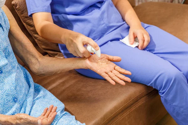 Äldre Kvinna Som Applicerar Handdesinfektionsgel Från Vårdgivare För Att Skydda — Stockfoto