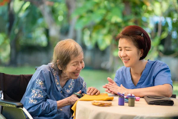 Oudere Vrouw Met Verzorger Naald Ambachten Ergotherapie Voor Alzheimer Dementie Rechtenvrije Stockafbeeldingen