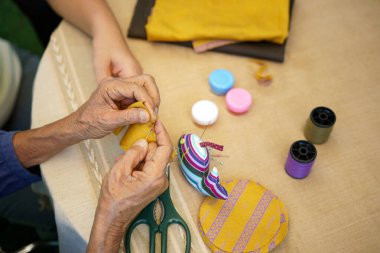 İğne ustası yaşlı bir kadın Alzheimer ya da bunama için meslek terapisi yapıyor.