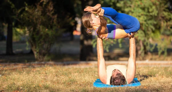 Joven pareja deportiva haciendo ejercicios de acro yoga — Foto de Stock