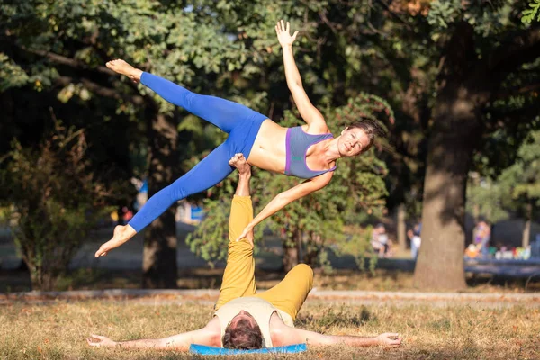 Acroyoga couple doing side star pose in the park — Stock Photo, Image