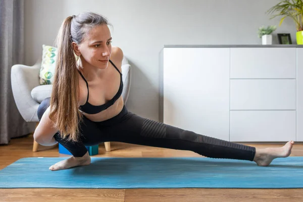 Junge Frau macht während Quarantäne Yoga zu Hause — Stockfoto