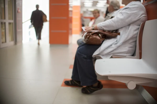 Närbild på stolar för patient och besökare på sjukhus, oskärpa personer — Stockfoto