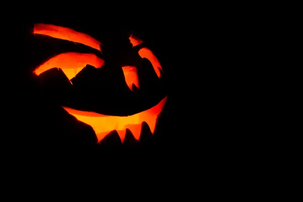 Gesneden gezicht van de pompoen gloeien op Halloween zwarte achtergrond — Stockfoto