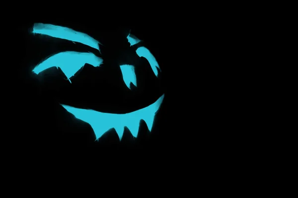 Cara tallada azul de calabaza que brilla sobre fondo negro de Halloween —  Fotos de Stock