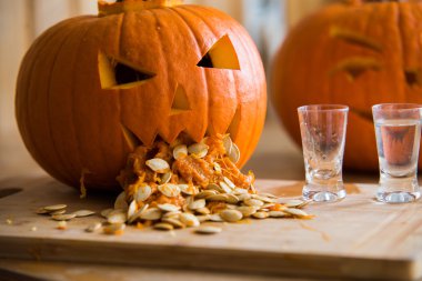  Pumpkin puking with pumpkin seeds on wood table, vodka clipart