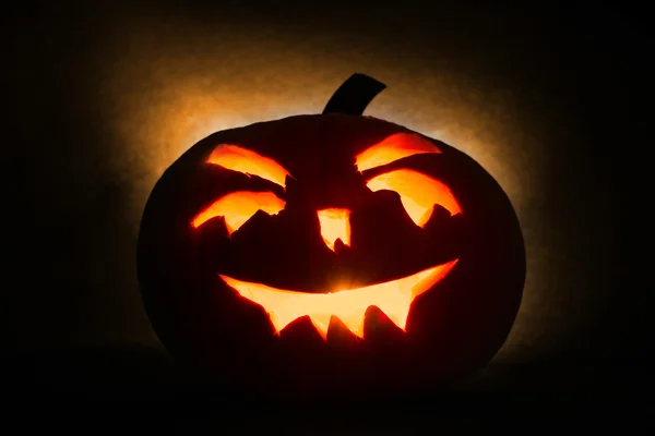 Halloween pumpa huvud jack lykta med brinnande ljus på orange bakgrund — Stockfoto