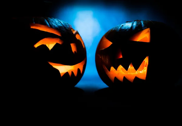Twee Scary Halloween pompoenen op een blauwe lichte achtergrond. — Stockfoto