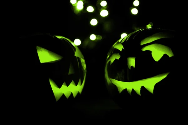Zwei Halloween-Kürbisse mit grünem Bokeh-Licht auf schwarzem Hintergrund — Stockfoto