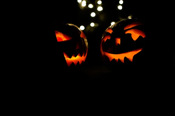 İki Halloween pumpkins bokeh ışık siyah arka plan üzerine — Stok fotoğraf