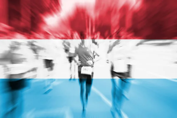 Marathon runner motion blur with blending Bandeira do Luxemburgo — Fotografia de Stock