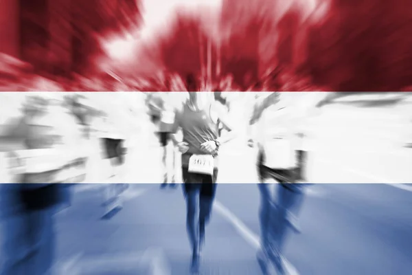 Marathon löpare rörelseoskärpa med blandning Nederländerna flagga — Stockfoto