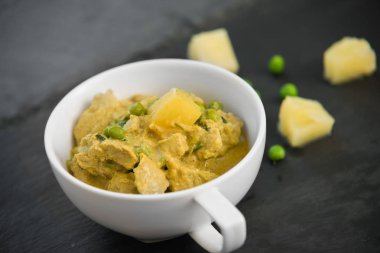 Siyah taş arka planda ananas, bezelye ve domuz yahnisi