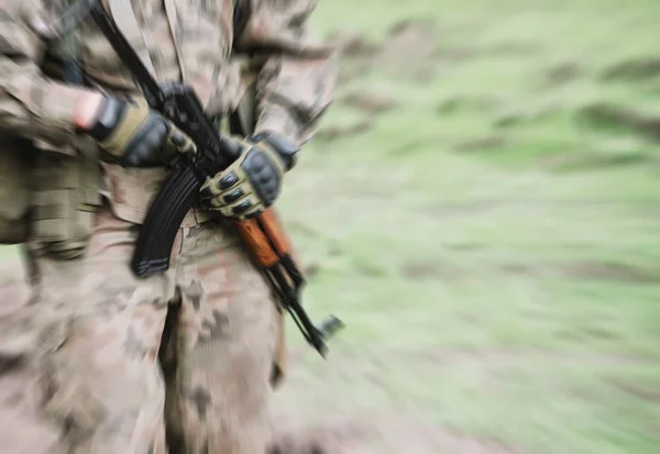 Close up on soldier with machine gun, motion blur — Stock Photo, Image