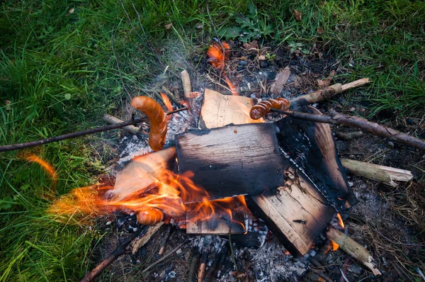 Salchicha en un palo, chimenea en el camping Imagen De Stock
