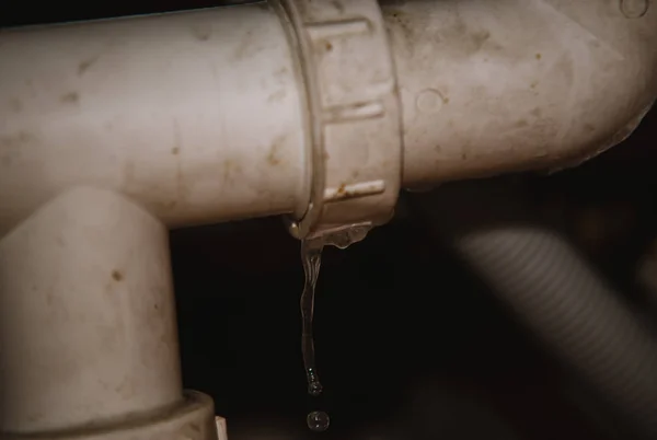 Echte Leckage von Wasser aus Rohr auf dem heimischen Hintergrund — Stockfoto