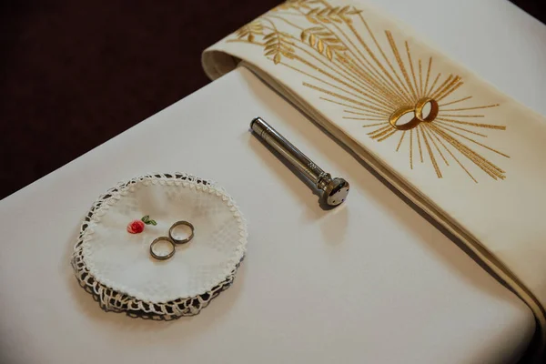 Anéis de casamento na igreja com ferramentas para ordenação — Fotografia de Stock