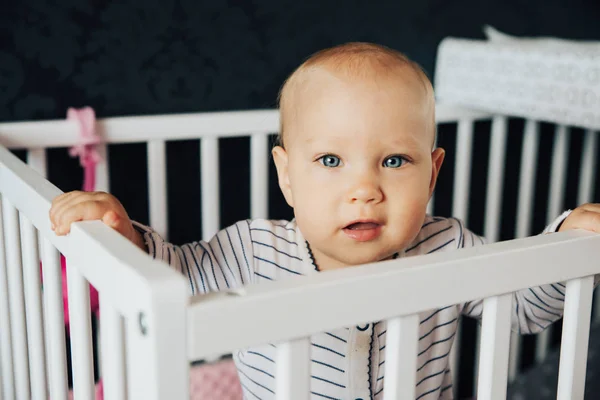 Mädchen mit blauen Augen und Blondine steht in ihrem Bett — Stockfoto