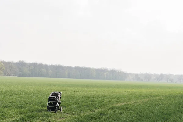 Wandelwagen achtergelaten in het veld, kind verloren Stockfoto