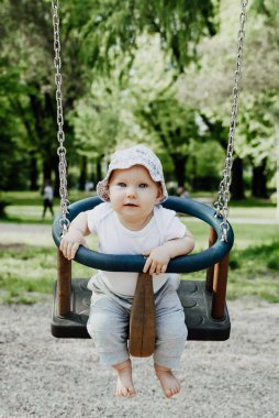 Küçük çocuk salıncakta eğleniyor.