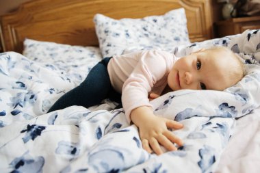 Bebek anne yatağında gülümsüyor.
