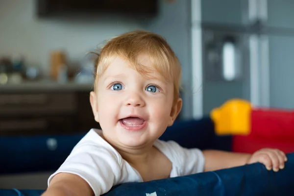 Laughing baby standing in a cot — Stock Photo, Image