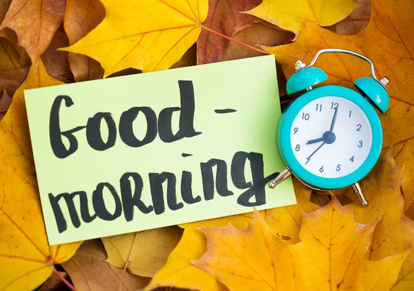 Good morning text and clock in leaves — Stock Photo, Image