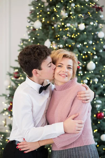 Anne ve oğlu Noel ağacını süslüyor. Anne ve oğul birbirlerine sarılırlar.