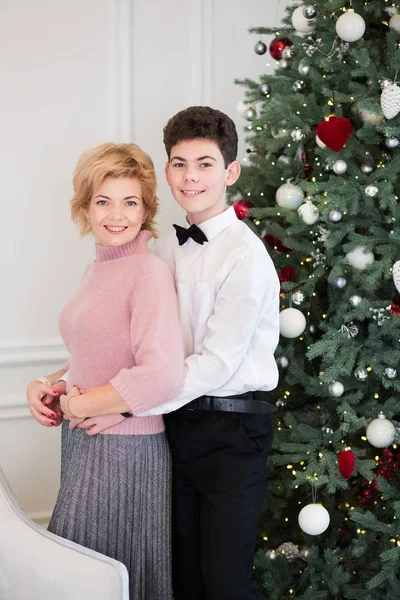 Maman et son fils décorent l'arbre de Noël. Maman et fils câlin près — Photo