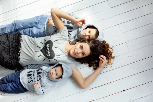 Mãe bonita com seus filhos abraçar e rir Fotografia De Stock