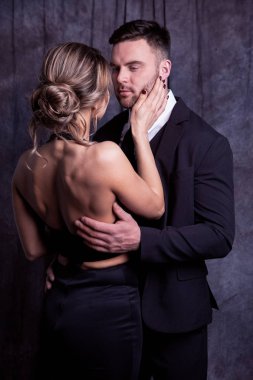 Zarif erkek ve kadın şefkatle kucaklaşır birbirlerini, sevgi dolu gözlerini almadan.