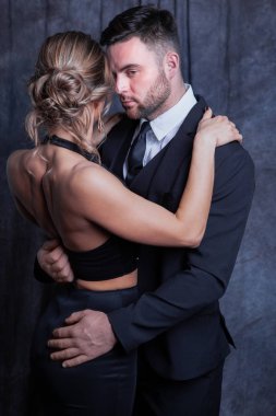 Zarif genç bir çift birbirini nazikçe kucaklıyor, bir tutku anında bir erkek mütevazı bir şekilde reddedilmiş bir kadının elbisesinin düğmelerini açmaya çalışıyor.