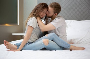 sevgi dolu bir genç çift evde yatakta öpüşme yan görünüm